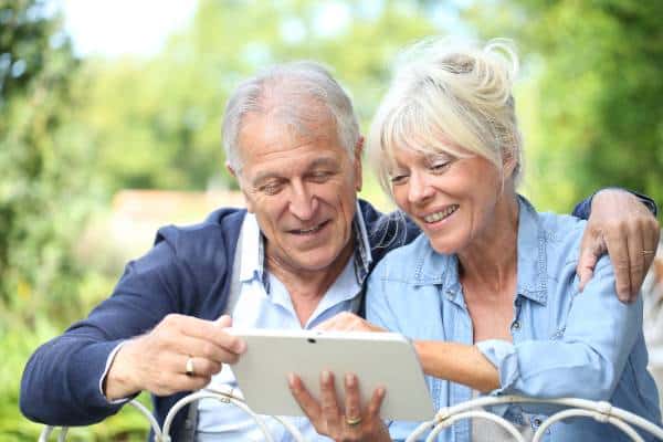 Boomer couple checking Final Expense Life Insurance rates on their tablet.